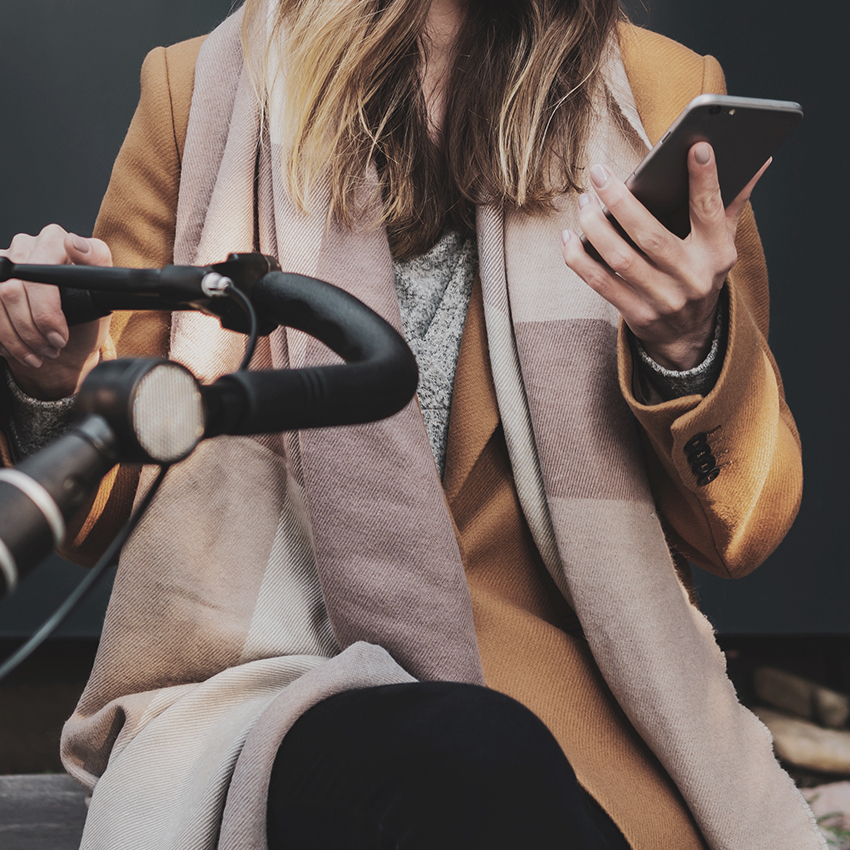 woman looking at phone pushing stroller