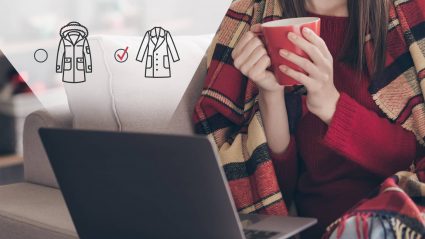 Person holds coffee mug while looking at computer