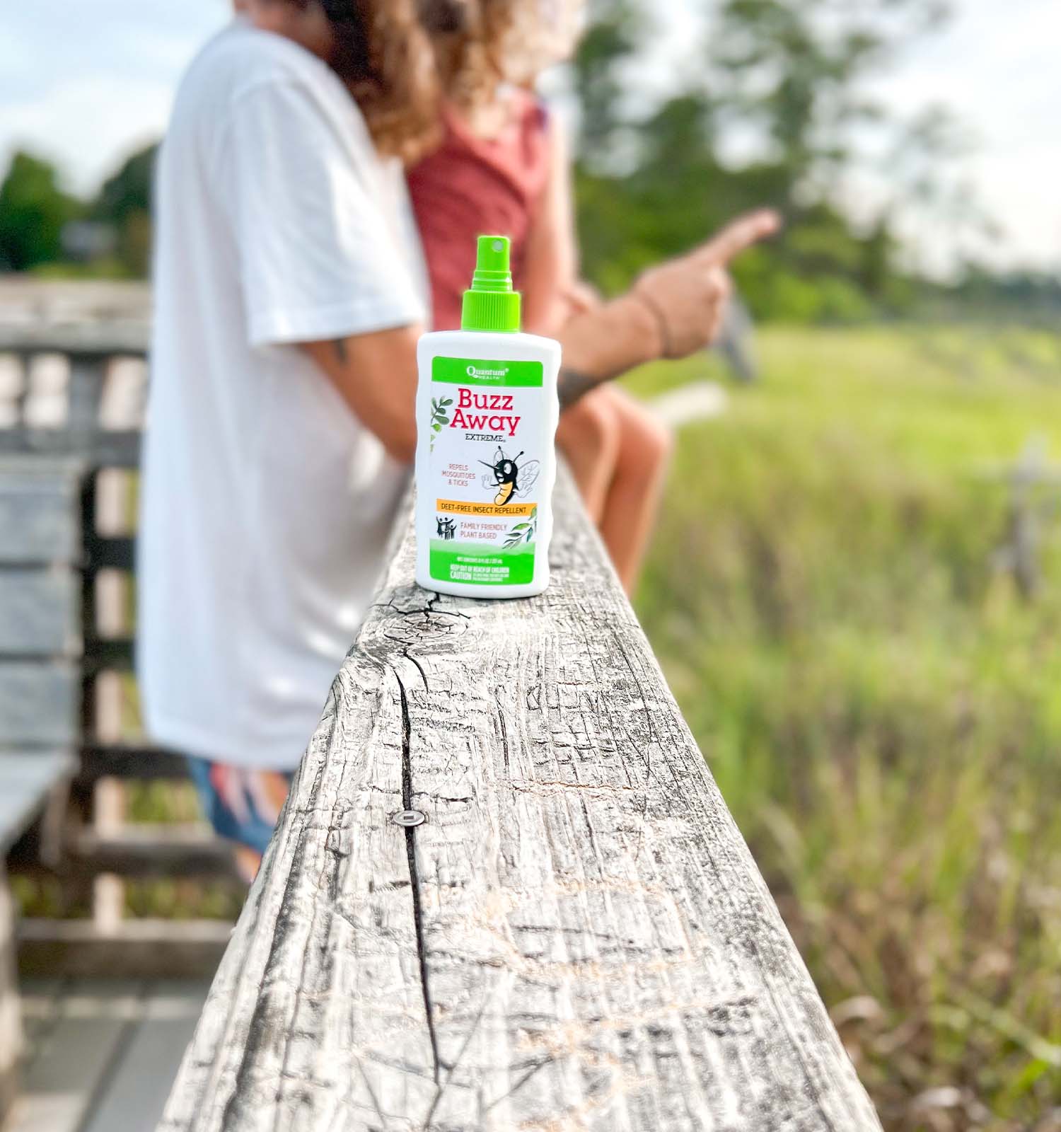 Quantum Health Buzz Away bug spray on a deck railing